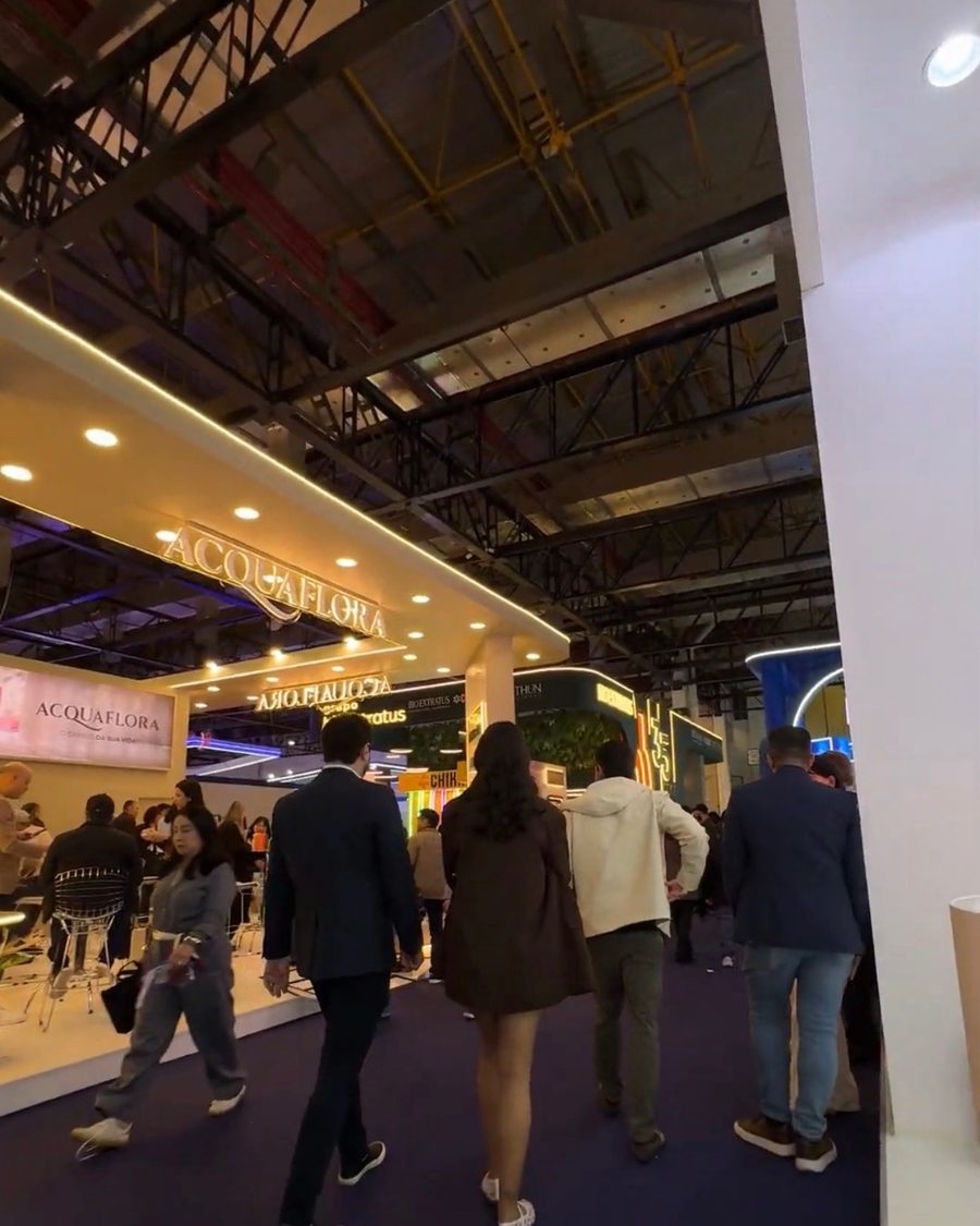 Corredor de feira da indústria cosmética com estandes de marcas